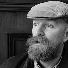 Black-and-white portrait of Brian John Spencer wearing a flat cap.