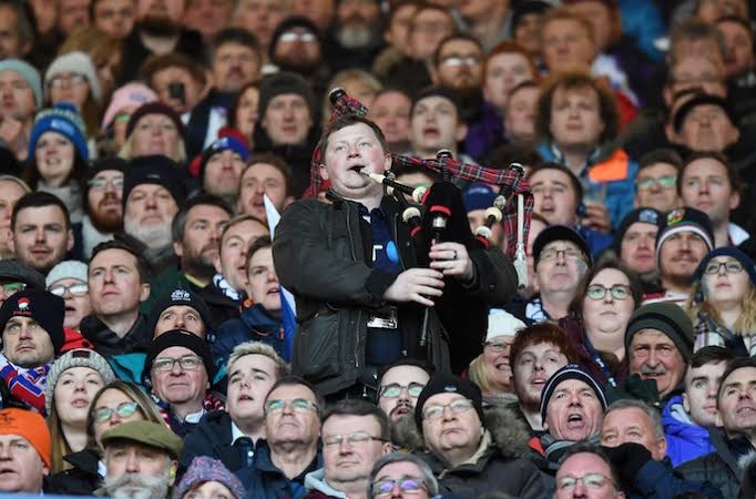 A piper plays to a packed Murrayfield grandstand on a cold international match day