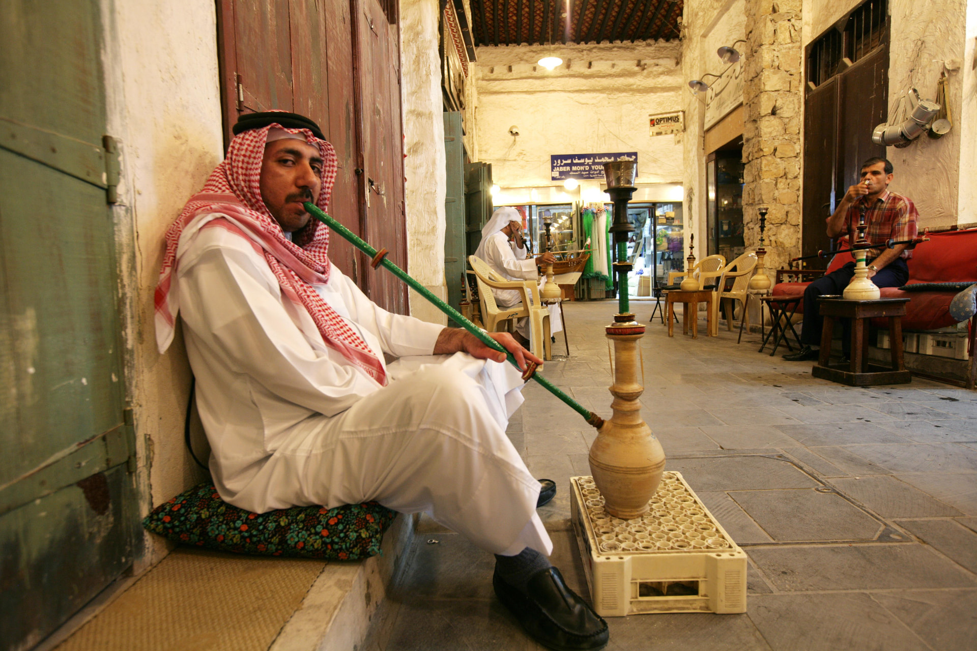 Men smoking shisha in a passage of Souq Waqif, Doha