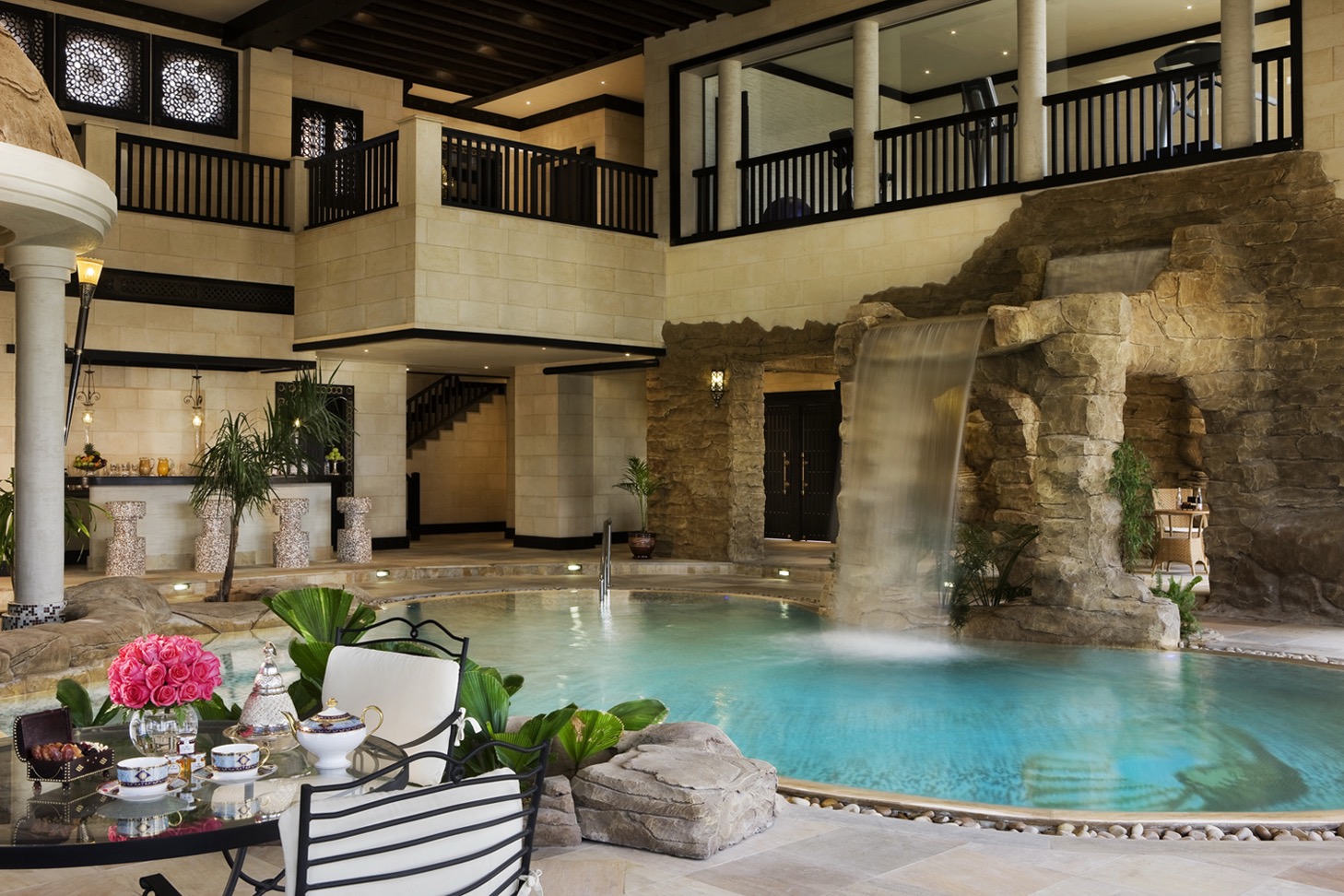 Tea laid beside an indoor courtyard pool in Doha